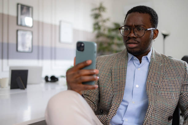 istock Serious black businessman using smart phone in the office. 2065364006