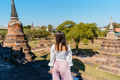 Rear-view of a young woman at Wat Ratchaburana in Ayutthaya historical park in Ayutthaya in Thailand.