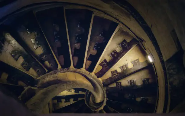 Photo of Ancient spiral staircase. Dark and gloomy.