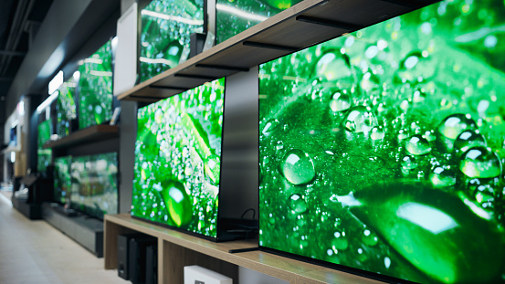 Department Store Electronics Section Showcasing a Range of of Modern Big TVs. Assorted Flat-Screen Televisions Convey Modernity and Technological Advancement with Perfect Quality and 4K Resolutions