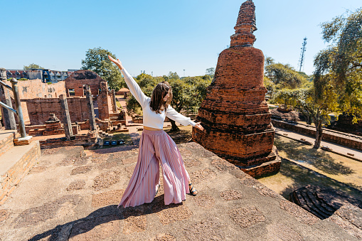 Young woman dancing at Wat Ratchaburana in Ayutthaya historical park in Ayutthaya in Thailand.