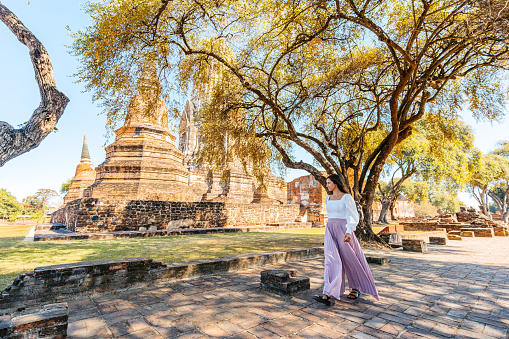 Young woman walking at Wat Ratchaburana in Ayutthaya historical park in Ayutthaya in Thailand.