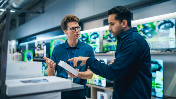 istock Young Multiethnic Customer Advising with Retail Home Electronics Store Salesperson. Stylish Man is Interested in Buying a Smartphone. Client Shopping for a New Cellphone in a Modern Shop 2065408708