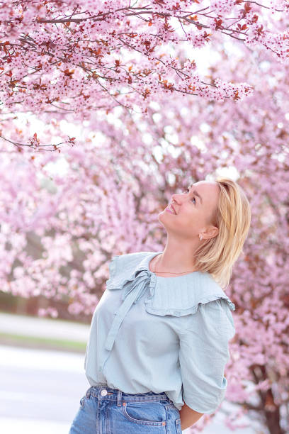 istock woman among beautiful cherry blossoms in full bloom 2065416248