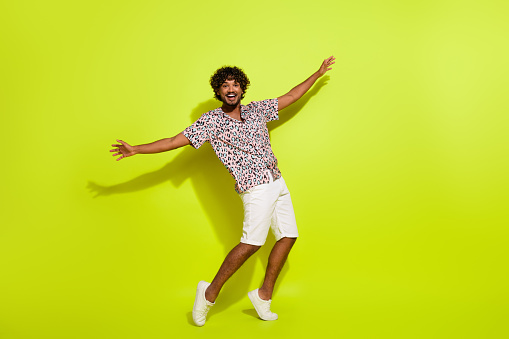 Full length photo of nice young man discotheque dance celebration dressed stylish striped leopard print isolated on yellow color background.