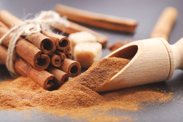 istock Cinnamon powder with sticks and star anises on black background 2065442189