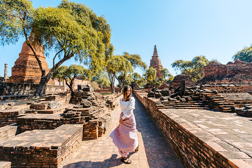 Young woman spinning around at Wat Ratchaburana in Ayutthaya historical park in Ayutthaya in Thailand.