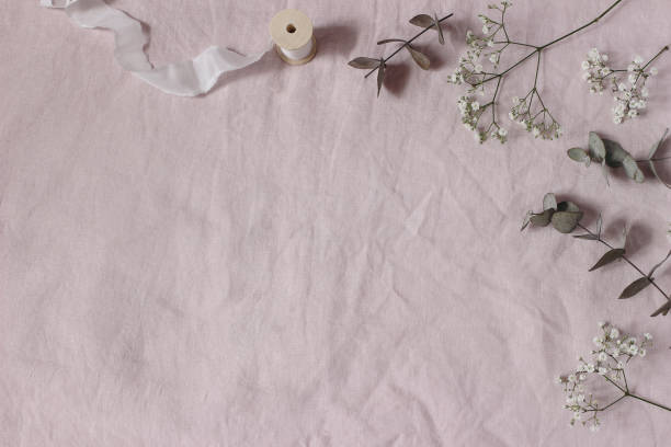 istock Floral wedding, birthday table composition. Gypsophila, eucalyptus tree leaves leaves and silk ribbons on pink linen table cloth background. Flat lay, top view. Copy space, no people. 2065456528