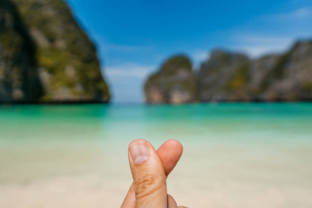 Young man's fingers snapping on the beach at the Ko Phi Phi islands in Maya bay in Thailand. His POV.