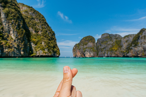 Young man's fingers snapping on the beach at the Ko Phi Phi islands in Maya bay in Thailand. His POV.