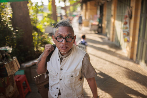 Mature Asian man walking on the street in Bangkok.