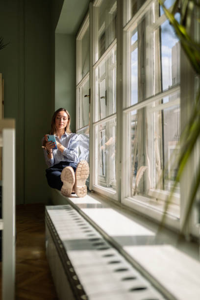 istock Businesswoman Navigating Digital Realm on Window Ledge 2065495851