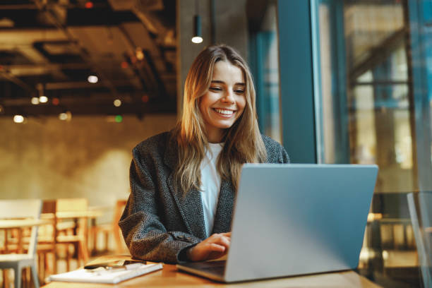 istock Stylish young female freelancer working on laptop while sitting in cozy cafe 2065502871