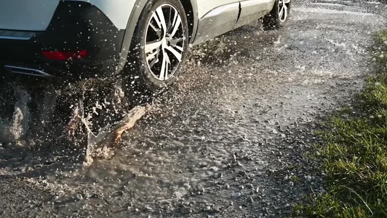 Car hitting a pot hole and splashing