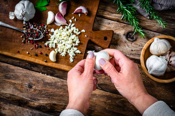 istock Overhead view of woman's hands peeling garlic bulb 2065528044