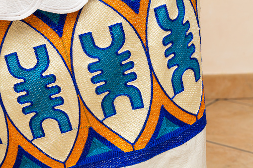 Close-up view of a vibrant African textile design featuring intricate embroidery and bold geometric patterns, showcasing the rich cultural heritage and craftsmanship