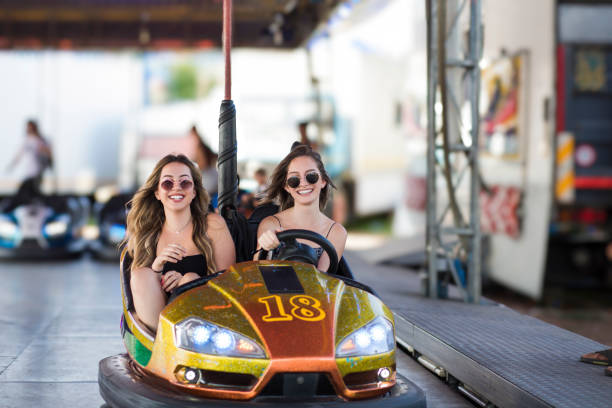 istock Two young women having a fun bumper car ride at the amusement park. 2065540337