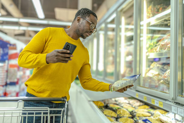istock Man choosing groceries from fridge in supermarket 2065540890