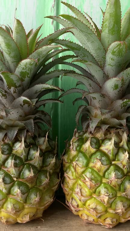 Row of pineapples against a turquoise background.