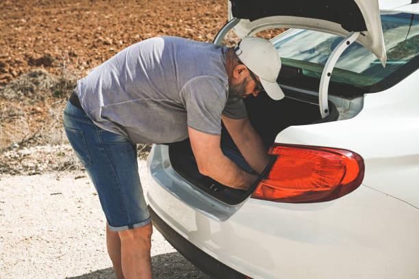 man stands by a broken car - stranded travel people traveling disappointment - fotografias e filmes do acervo