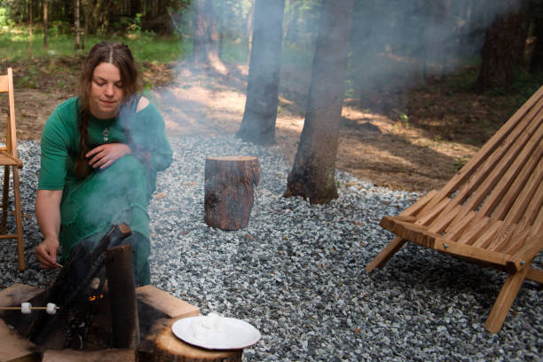 istock alone woman cooking  marshmallow bbq on campfire outdoors 2065583361
