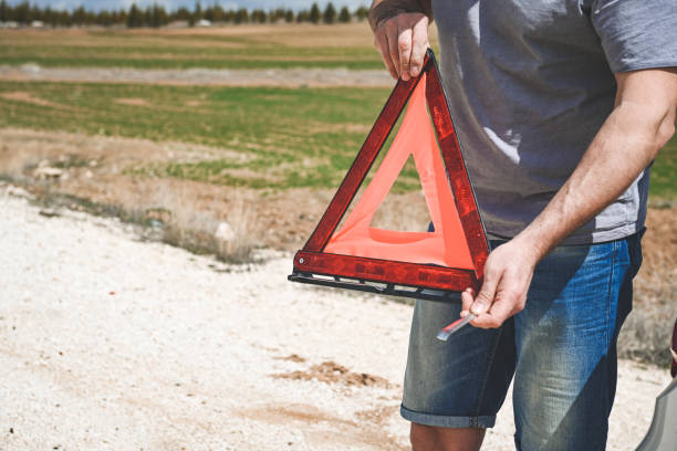 man stands by a broken car - stranded travel people traveling disappointment - fotografias e filmes do acervo