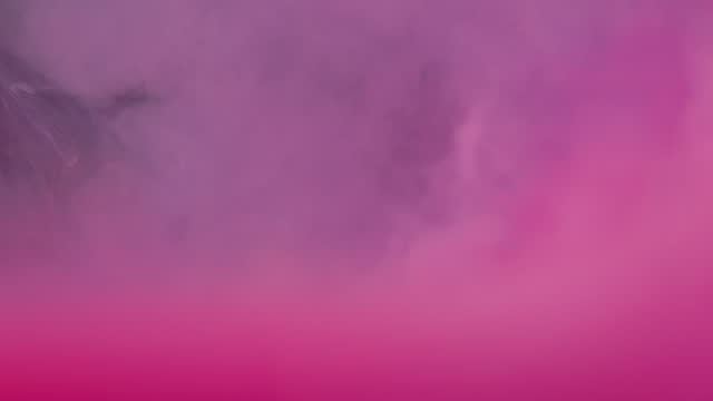 Close up slow motion of Pink color ink in water, like an explosion or clouds