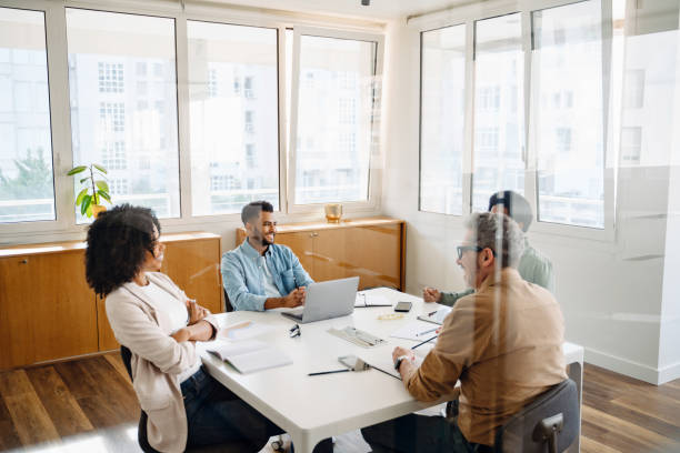 istock A team of four professionals are gathered around a white table in a modern office 2065627417