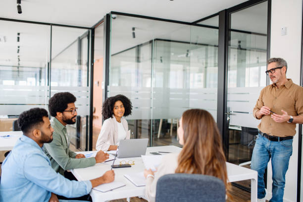 istock In a modern office, a man in a tan shirt gestures during a dynamic presentation 2065627437