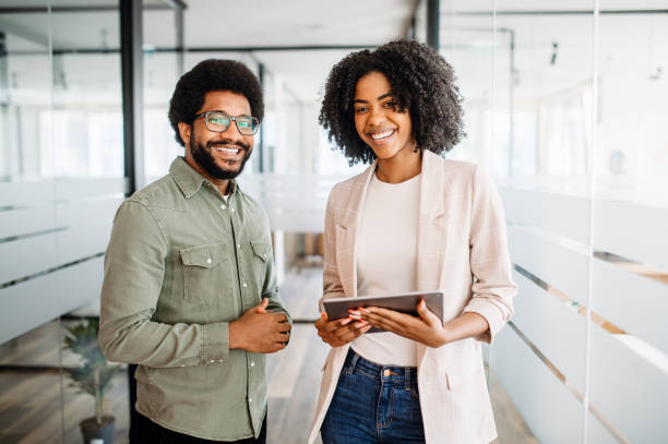 Two colleagues stand side by side in a modern office space