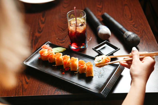 istock Person Eating Sushi With Chopsticks on Table 2065665802
