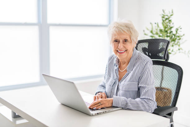 istock senior women using a laptop while sitting at the office 2065673443