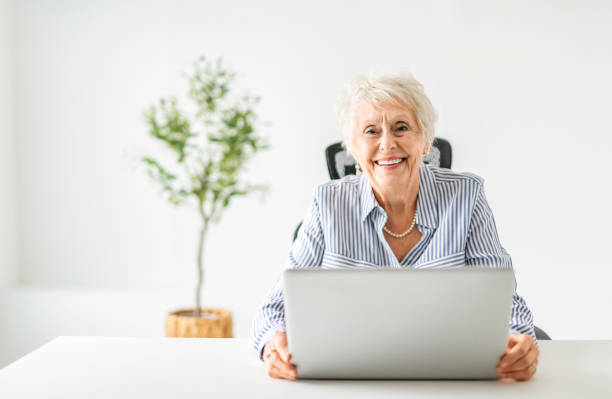istock senior women using a laptop while sitting at the office 2065673857