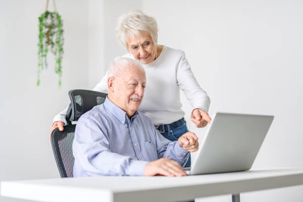 istock senior couple using a laptop while sitting at the office 2065673900
