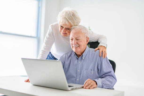 istock senior couple using a laptop while sitting at the office 2065673915