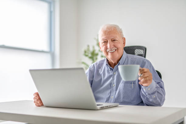 istock senior men using a laptop while sitting at the office 2065674454
