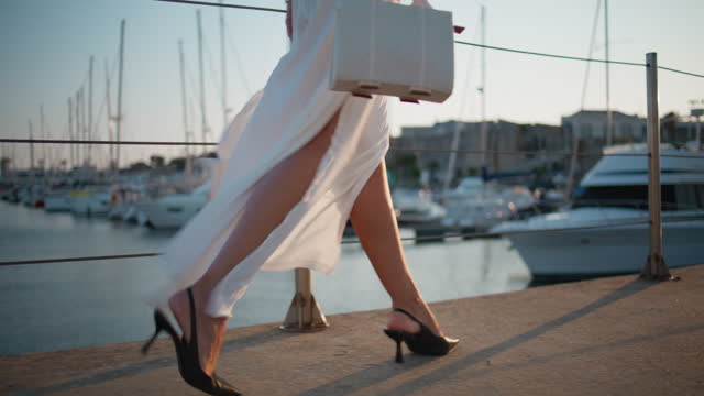 High-heels legs going embankment summer evening close up. Unknown woman walking