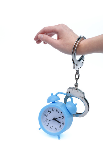 The time remaining in prison for an inmate, a clock handcuffed to a man's hand