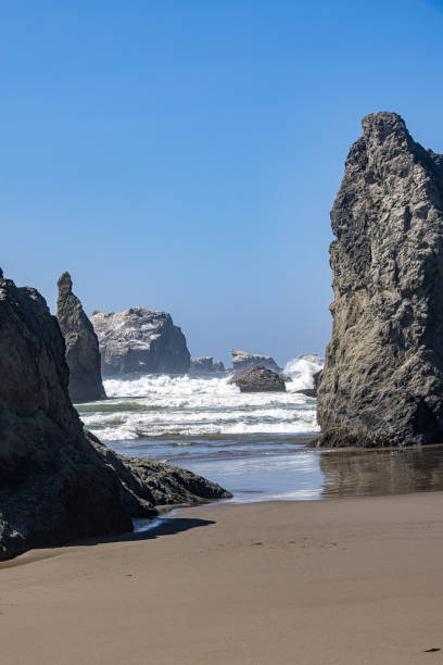 istock Crashing Pacific Ocean waves on the shore with large sea stacks and clear blue sky 2065695308