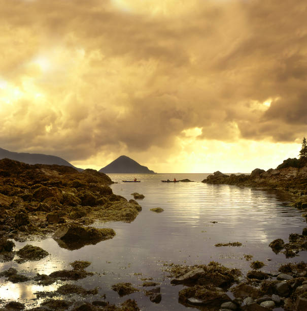 Queen Charlotte Islands, Canada - sea with kayaks and islands at sunset