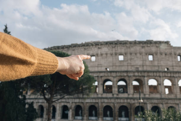 A person pointing to the Roman Colosseum