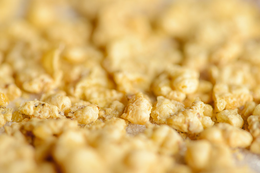 Extreme macro of corn flakes crumbs on sugar crystals