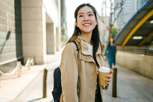 Sustainability Asian japanese Gen Z holding disposable coffee cup smile realxing travel and walking on street morning at kyoto japan