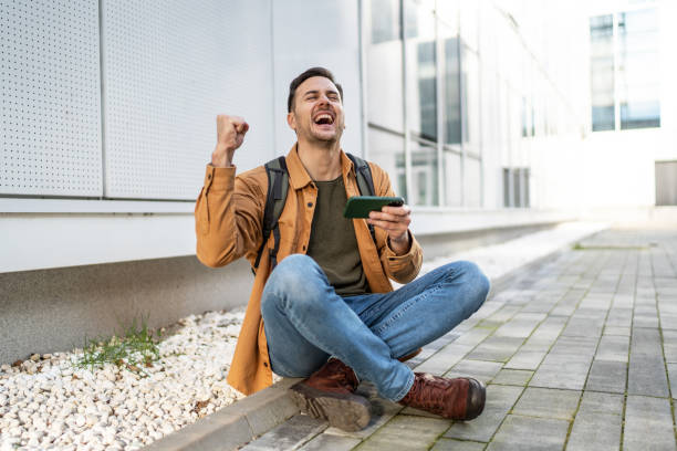 istock Cheerful man playing video games on smartphone 2065696781