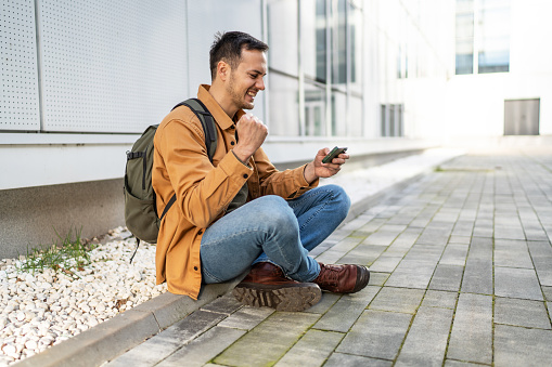 Cheerful man playing video games on smartphone