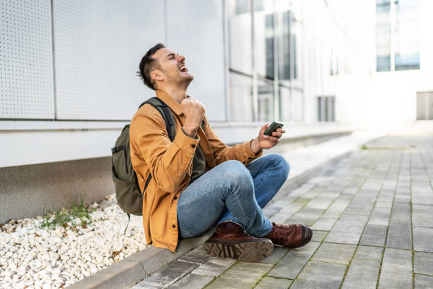 istock Cheerful man playing video games on smartphone 2065696884