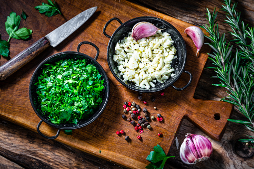 Chopped garlic and parsley on wooden cutting board