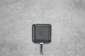 Square grill pan on a cement background
