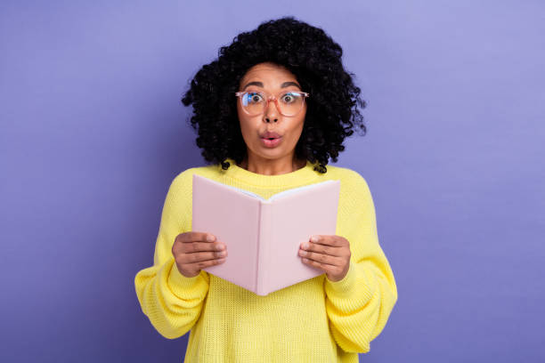 istock Portrait of impressed astonished person with chevelure wear pullover read interesting book staring isolated on purple color background 2065723934