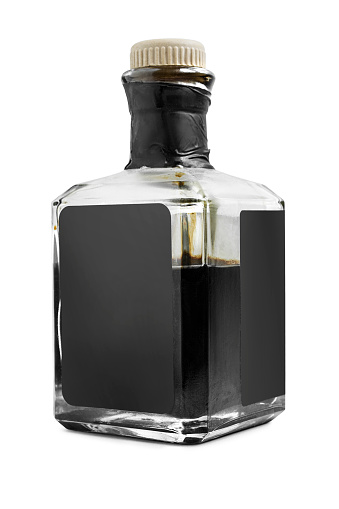 Half full black vinegar bottle isolated on white background